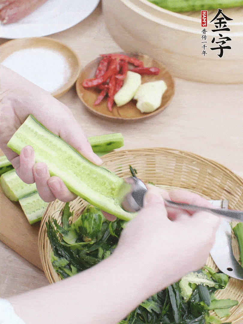 黃瓜削皮，對(duì)半切開，勺子挖去內(nèi)瓤，斜刀切片。青蒜斜刀切段。
